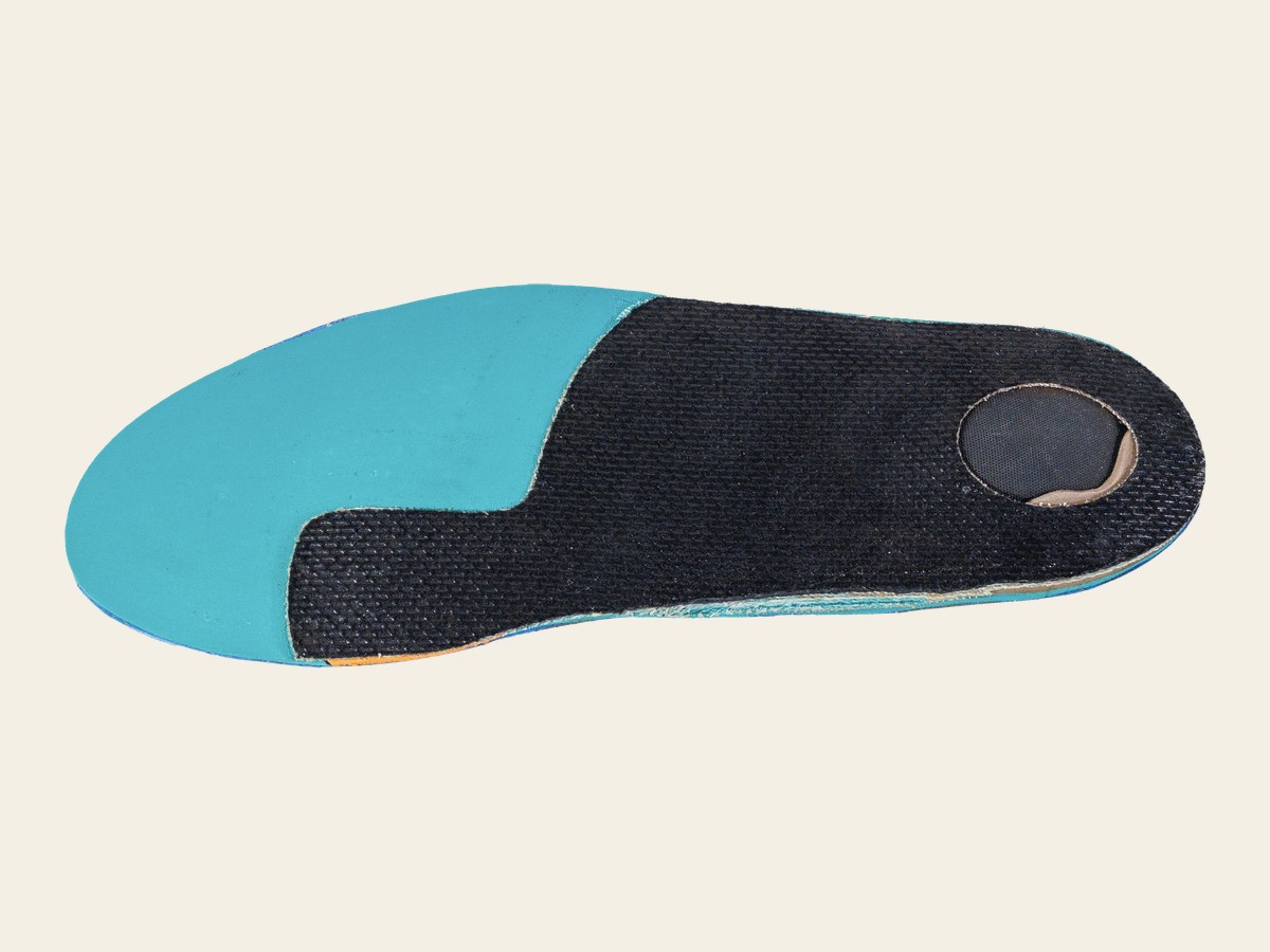 Finished custom-made orthotic showing the carbon-fibre shell and cushioned top